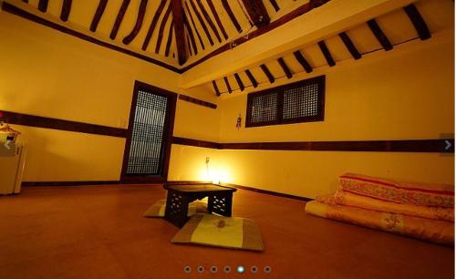 a room with a table and a lamp on the floor at Gohyundang in Jeonju