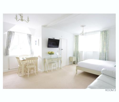 a bedroom with a bed and a table and a dining room at The Old Stables in Minehead