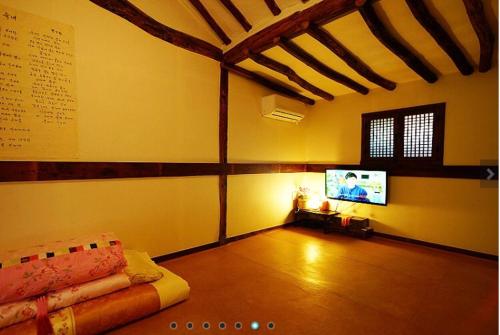 a room with a tv and a couch in a room at Gohyundang in Jeonju