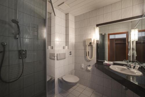 a bathroom with a shower and a toilet and a sink at Hotel-Gästehaus Alte Münze in Bad Mergentheim