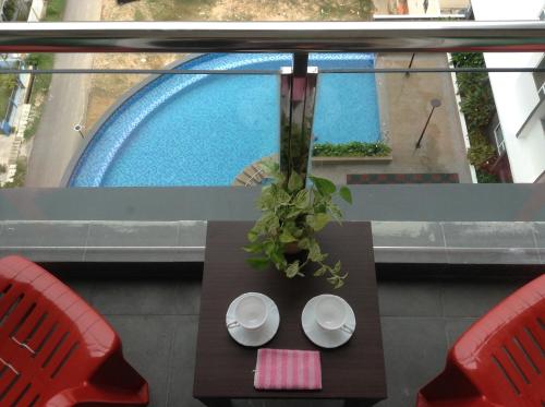 a table and two red chairs and a pool at 888@D'Perdana Sri Cemerlang in Kota Bharu