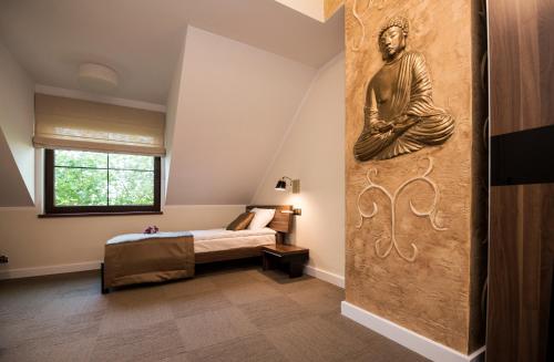 a bedroom with a buddha mural on the wall at Apartamenty Giżycko in Giżycko