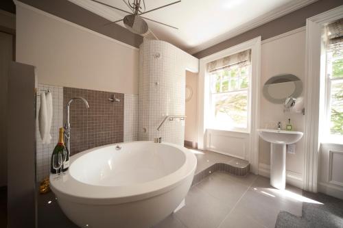 a white bathroom with a tub and a sink at Kilmore Country House in Glenariff