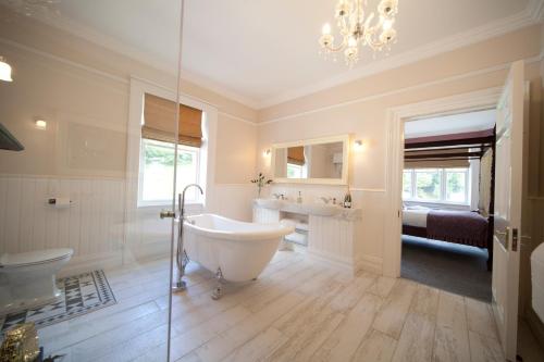 a bathroom with a tub and a sink and a toilet at Kilmore Country House in Glenariff