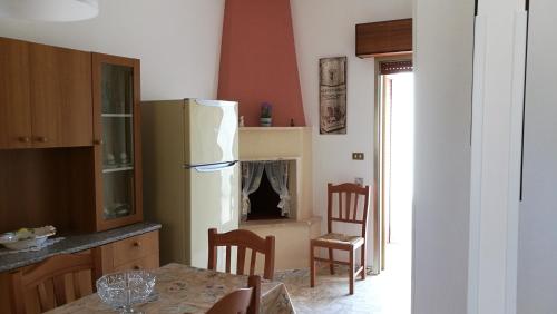 トッレ・サン・ジョヴァンニ・ウジェントにあるCasa Dasy - Torre San Giovanni di Ugento ( Le )のキッチン(冷蔵庫、テーブル、椅子付)