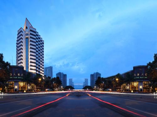 una calle de la ciudad por la noche con un edificio alto en Kunming Haitian Hotel, en Kunming