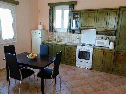 een keuken met een tafel en stoelen, een fornuis en een koelkast bij Gythio Seaside Villa Dimitrios - Panoramic View in Gythio
