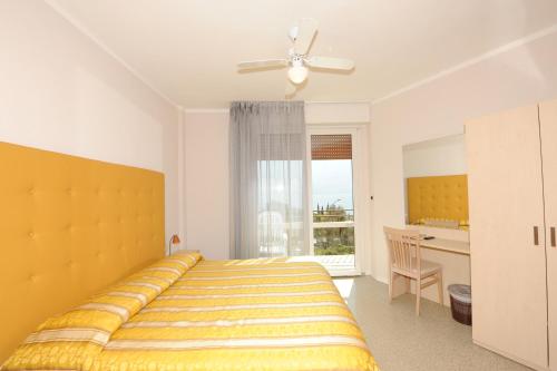 a bedroom with a bed and a desk and a window at Hotel Villa Grazia in Limone sul Garda