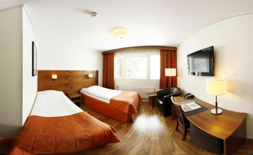 um quarto de hotel com duas camas e uma secretária em Kraja em Arjeplog