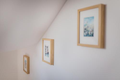 two framed photographs on a wall in a room at City Apartment One in Mostar