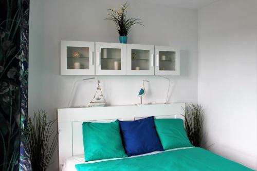 a bedroom with a bed with green and blue pillows at Luxury house in El Médano in El Médano