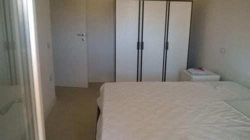 トルトレート・リドにあるResidenza il Grecaleのベッドルーム(ベッド1台、白いワードローブ付)