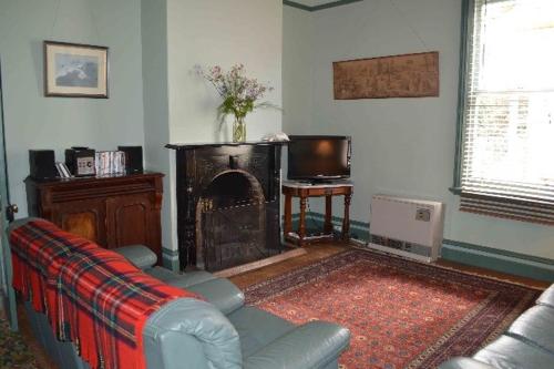 a living room with a couch and a fireplace at Albion Cottage in Queenscliff