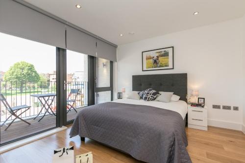 1 dormitorio con 1 cama grande y balcón en Urban Chic - Portobello, en Londres