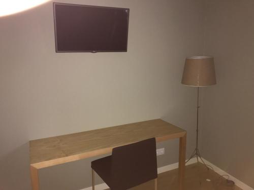 a desk with a television on a wall with a lamp at Hotel Medieval® de Penedono in Penedono