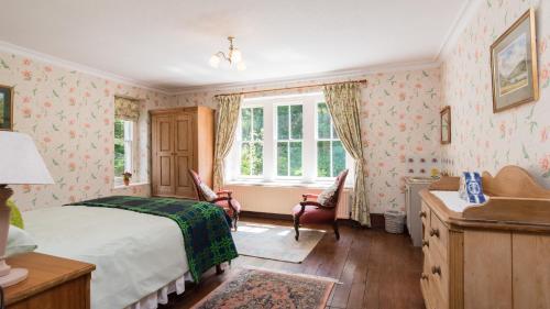 a bedroom with a bed and a desk and a window at Farchynys Hall in Barmouth