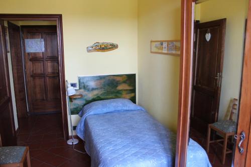 1 dormitorio con cama y espejo en Bio Agriturismo Podere Pretoia, en San Gimignano