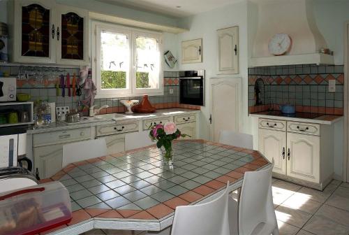a kitchen with a table with a vase of flowers on it at Villa hortensia in Carpentras