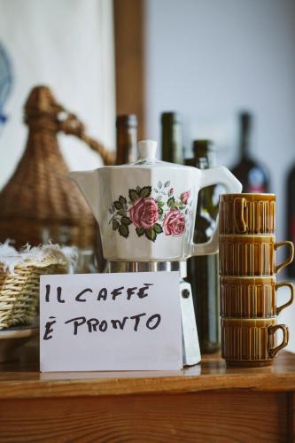a tea pot and a cup on a table at Villa Venti - Craft Wine & Hospitality in Roncofreddo