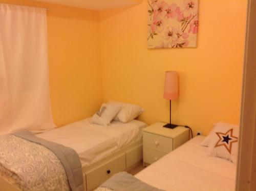 a small bedroom with two beds and a lamp at Mojoy Homesuites At Runyon in Newark