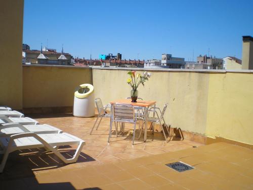 a patio with a table and chairs on a roof at Apartamentos Augusta Centro in Zaragoza