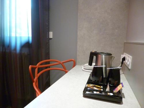 a kitchen counter with a coffee maker on a table at Hôtel Logis Restaurant La Fontaine in Mantry