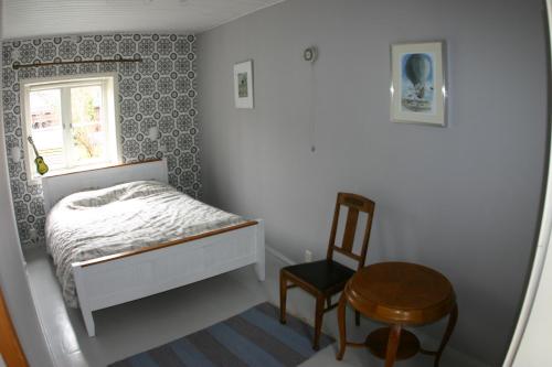 ポルヴォーにあるVacation Home in Old Town Porvooの小さなベッドルーム(ベッド1台、椅子付)