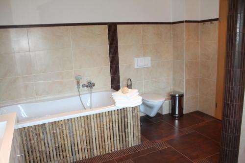 a bathroom with a tub and a toilet at Seaside Villa Leipzig in Leipzig