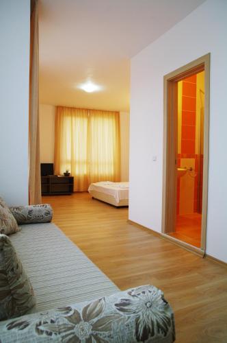 a living room with a bed and a large mirror at Guest House ASK in Primorsko