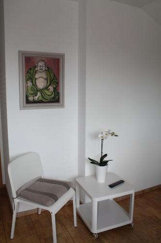 a white room with a chair and a table at Seaside Villa Leipzig in Leipzig