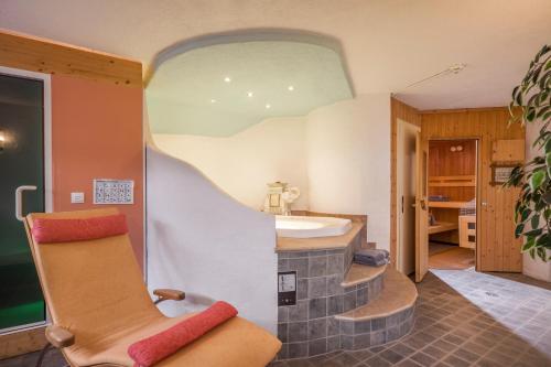 a bathroom with a sink and a chair in a room at Biolandhaus Seethaler in Vorderthiersee