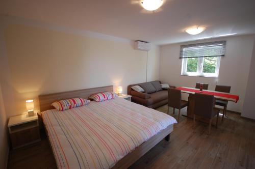um quarto com uma cama, uma secretária e um sofá em Apartment Bazdaric em Sveti Vid-Miholjice