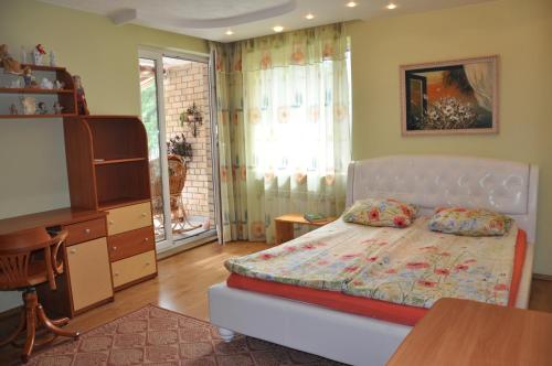 Schlafzimmer mit einem Bett, einem Tisch und einem Schreibtisch in der Unterkunft Apartamentas Zunda in Nida