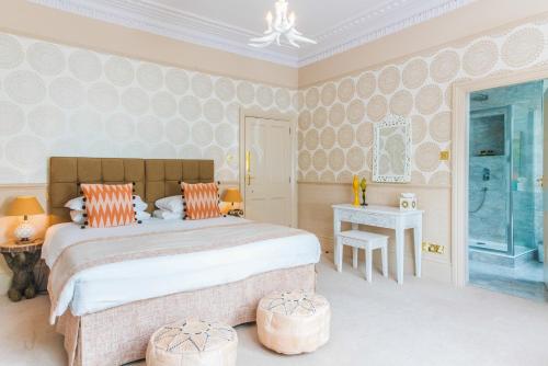 a bedroom with a large bed with orange pillows at The Ayrlington Guesthouse in Bath