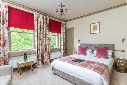 a bedroom with a bed and two windows at The Ayrlington Guesthouse in Bath