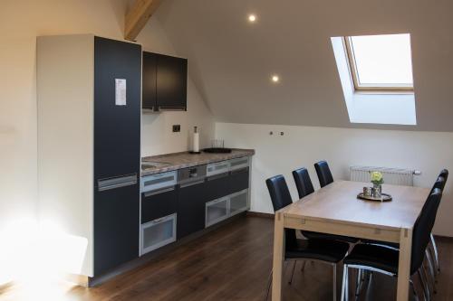 a kitchen with a wooden table and a dining room at Hotel Hubert in Slavonice
