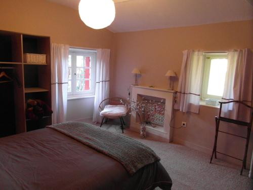 a bedroom with a bed and a chair and a fireplace at Chambres d'hôtes - B&B in Gétigné