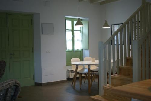 uma sala de jantar com mesa, cadeiras e escadas em Las Casinas de la Granda em Nueva de Llanes