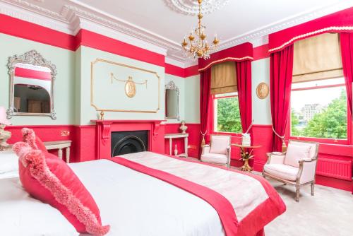 a red bedroom with a large bed and a fireplace at The Ayrlington Guesthouse in Bath