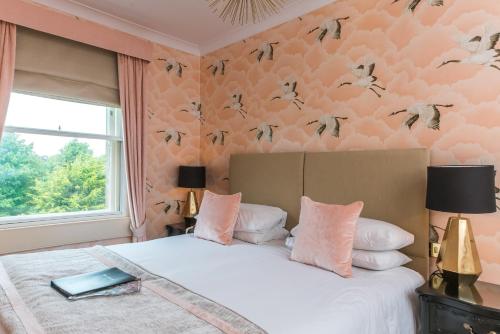 a bedroom with a bed with birds on the wall at The Ayrlington Guesthouse in Bath