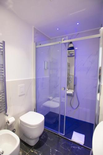 a bathroom with a toilet and a glass shower at San Pietro Grand Suite in Rome