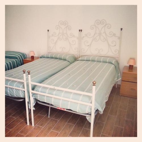 una camera da letto con due letti con lenzuola verdi e bianche di roseto holidays a Roseto degli Abruzzi