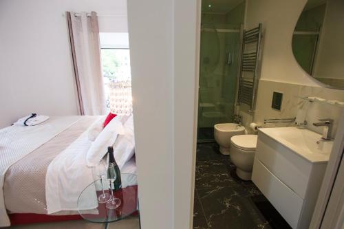 a bathroom with a bed and a sink and a mirror at San Pietro Grand Suite in Rome
