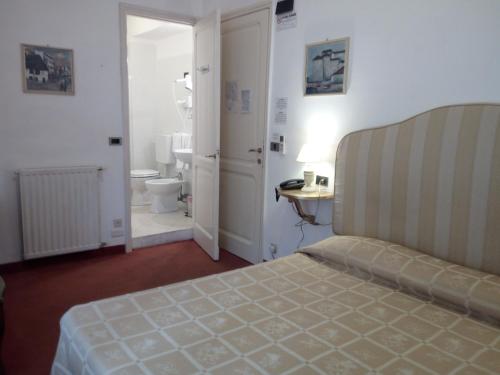a bedroom with a bed and a bathroom with a toilet at Hotel La Vela-Castello Il Rifugio in Santa Margherita Ligure