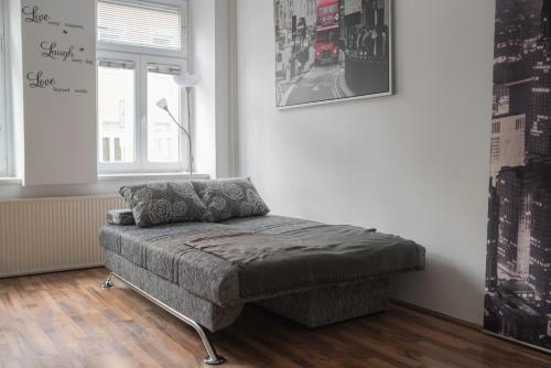 a couch sitting in a living room with a window at CityApartment-Maribor in Maribor