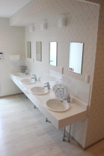 a bathroom with a row of sinks and mirrors at Tokyo Guest House 2020 in Tokyo