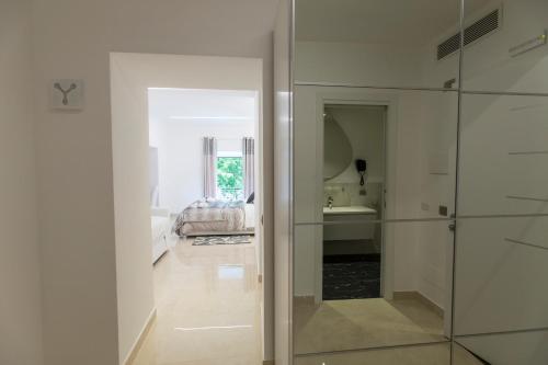 um corredor com uma porta de vidro que leva a uma casa de banho em San Pietro Grand Suite em Roma