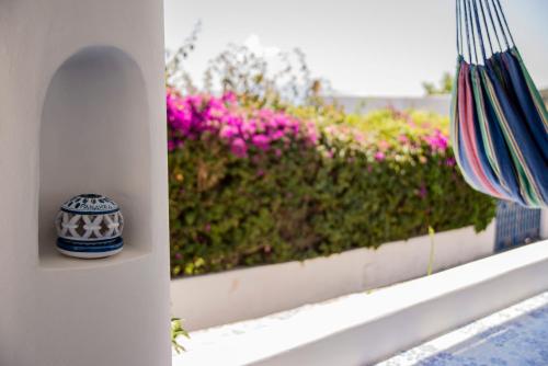 a vase sitting on a ledge with pink flowers at La Sirena in Panarea