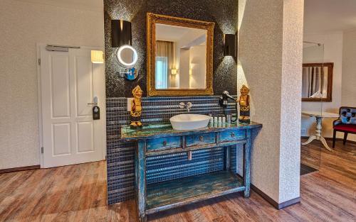 a bathroom with a sink and a mirror on a wall at SPREE Hotel in der Altstadt in Lübbenau