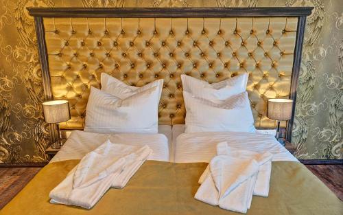a bed with white sheets and pillows on it at SPREE Hotel in der Altstadt in Lübbenau